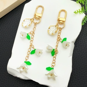 Detailansicht des weißen Maiglöckchen-Anhängers aus Acryl mit einer goldenen Metallkette