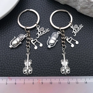 Detail of silver music keychains with violin, microphone, and I Heart Music charms