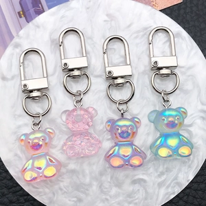 Detailed macro view of four colorful resin bear keychains with silver D-rings