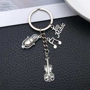 Detailed view of antique silver music keychain with violin, microphone, and music note