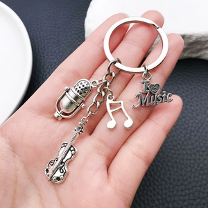 Antique silver music keychain featuring microphone, cello, and musical note charms