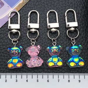 Detailed macro view showing four colorful resin bears with aurora coating and metal clasp
