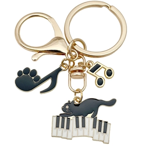 Golden keychain featuring a black piano cat and musical notes with black enamel finish