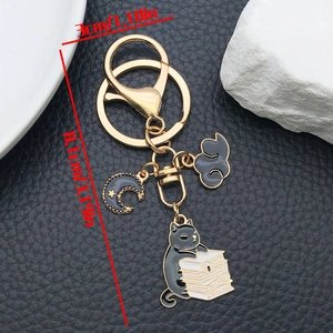 Detailed size view of a black cat reading on books keychain in gold-plated zinc alloy