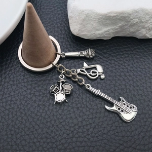 Detailed view of antique silver music charms with guitar and drum on leather background