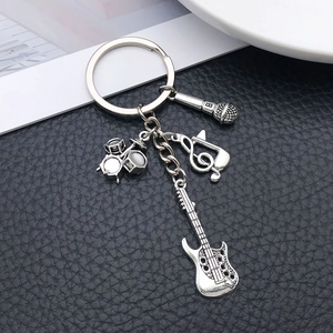 Detailed view of silver music keychain with drum kit guitar microphone and clef charms