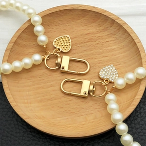 Faux pearl keychain with golden heart charms and diamond-studded heart pendant