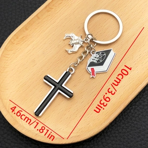 Gothic keychain with cross, silver bat and skull book charm on dark leather background