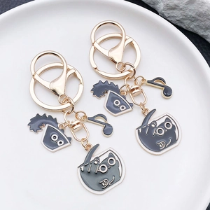 Cute black cat enamel keychain with golden alloy charms and music notes on white tray