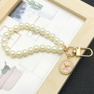 Détail du bracelet en perles avec fermoir doré et pendentif rose en relief élégant