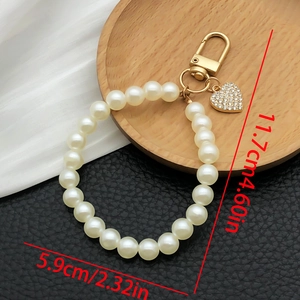 Detailed view of pearl heart keychain with size dimensions of 11.7cm and gold hardware