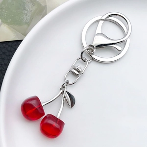 Detailed macro view of translucent red cherry charms on a silver metal keychain