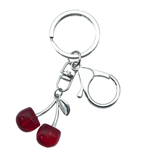 Transparent red cherry keychain with silver lobster clasp and ring on white background