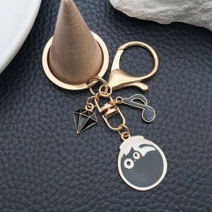 Porte-clés doré avec chat en émail noir, note de musique et pendentifs losanges