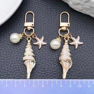 Marine style seashell keychain with starfish and pearl charms on a golden U-ring