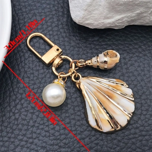 Detailed view of the ocean-themed keychain showing dimensions with shell and pearl charms