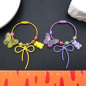 Detail view of colorful resin bear and butterfly charms on a steel wire keychain
