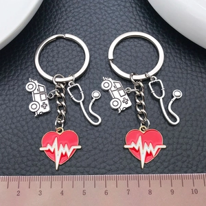 Antique silver stethoscope and ambulance keychain with red heart charm on leather