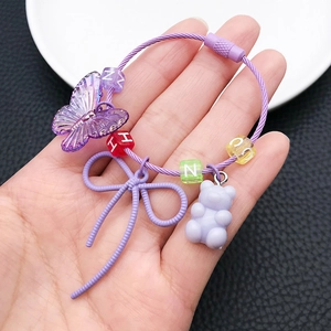 Close-up of purple resin beads keychain with bear, bow, and colorful letter beads