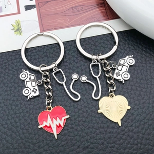 Detail of antique silver stethoscope keychain with red heart and heartbeat pattern charms