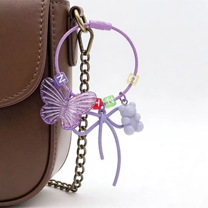 Detail view of purple resin bear and butterfly charm with colorful alphabet beads on a bag