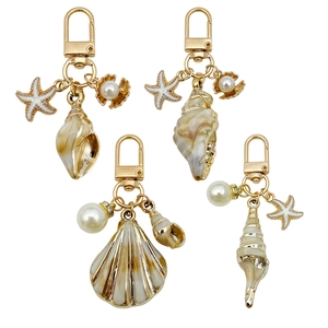 Set portachiavi minimalista con ciondoli dorati a forma di conchiglia, stella marina e perle