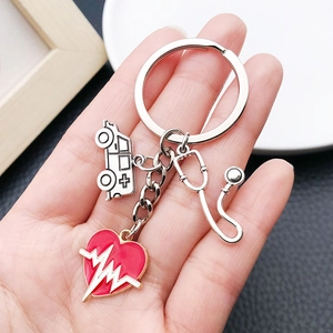 Detail of silver medical keychain with red heart, stethoscope and ambulance charms