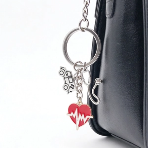 Detailed medical keychain featuring stethoscope and red heart charm on black leather bag