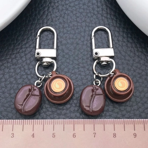 Detailed close-up of coffee bean keychains with cream latte art cup and measuring scale