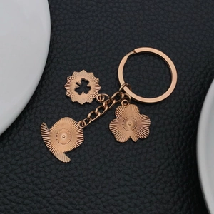 Detailaufnahme der roségoldenen Schlüsselanhänger mit Kleeblatt-Anhängern auf Leder