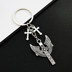 Vintage Silberlegierung Kreuz Schlüsselanhänger mit Flügeln auf schlichtem Hintergrund