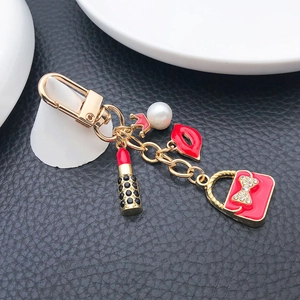 Porte-clés avec breloques rouge à lèvres et sac émaillé, perle sur fond en cuir noir élégant