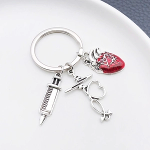Close-up of medical keychain with syringe, stethoscope and red anatomical heart charm