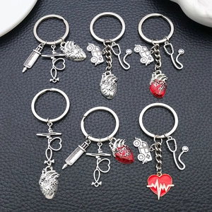 Detailed view of silver medical keychains featuring syringe and stethoscope on black leather