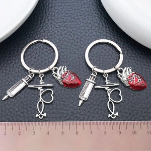 Antique silver medical keychain with syringe, stethoscope and red heart charms