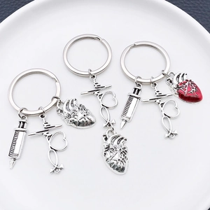 Antique silver medical keychain set featuring heart, syringe and stethoscope charms