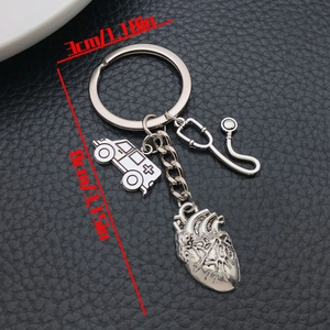 Detail view of medical keychain with stethoscope, ambulance, and heart charms on black leather