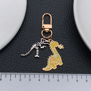 Porte-clés dinosaure jaune mignon avec breloque squelette argenté et motifs floraux