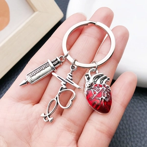 Close-up of medical keychain with syringe, stethoscope and red heart pendant
