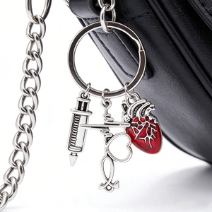Detail of medical keychain with silver syringe stethoscope and red heart on leather bag