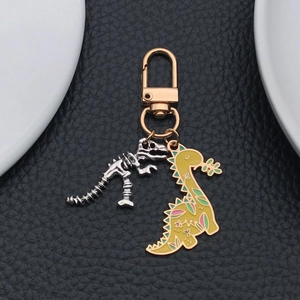 Détail d'un porte-clés dinosaure en émail jaune avec squelette en argent sur cuir