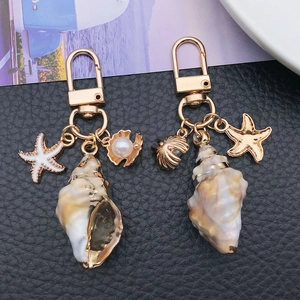 Porte-clés nautique avec conque naturelle, fermoir en U doré et accents de perles marines