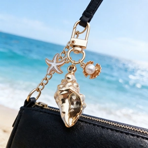 Bijou de sac coquillage doré et étoile de mer avec perle sur un sac à main en cuir