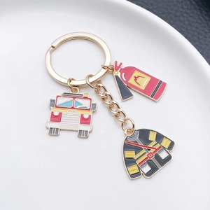 Close-up of firefighter keychain with red fire truck, extinguisher and uniform charms
