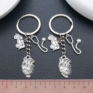 Antique silver medical keychain set featuring stethoscope, heart and ambulance charms