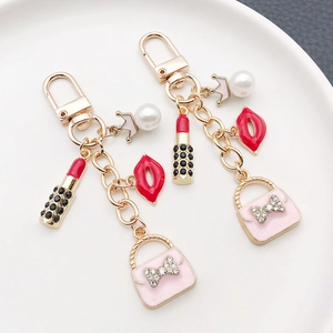 Porte-clés avec breloques sac à main rose et rouge à lèvres avec perles et couronne