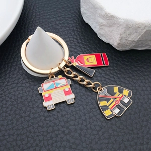 Creative fire safety keychain featuring red firetruck, extinguisher and uniform charms
