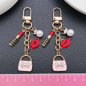Vue détaillée du porte-clés avec sac rose, perle couronne et pendentifs lèvres