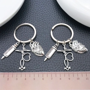 Antique silver medical keychain set featuring syringe, stethoscope, and heart pendants