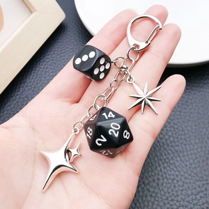 Close-up of black dice keychain with silver star charms and D20 gaming elements